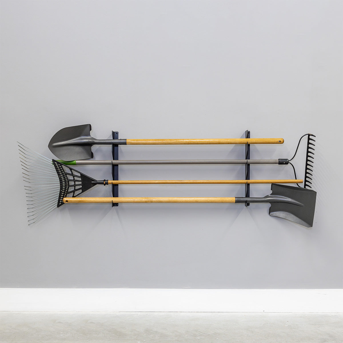 Shed tool organizer on a gray wall holding shovels and rakes horizontally