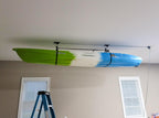 Kayak stored overhead on the ceiling hoist above a ladder
