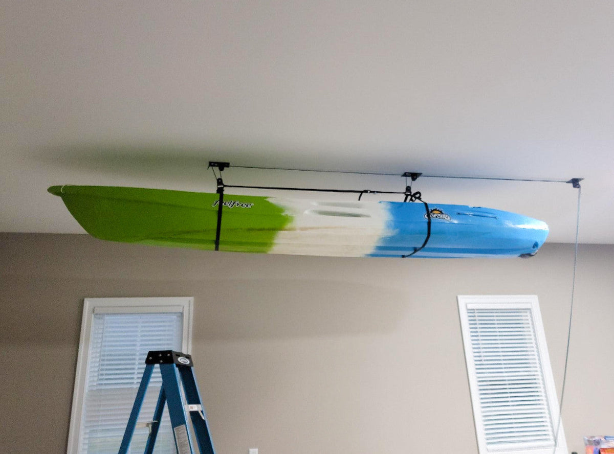 Kayak stored overhead on the ceiling hoist above a ladder