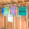 Lawn chair hooks holding four folding beach chairs on a shed wall