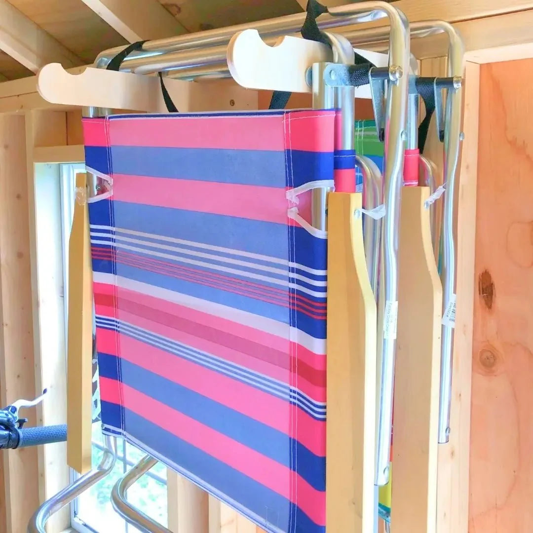 Striped folding beach chair hanging on a lawn chair hook