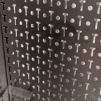 Close-up of the black steel PRO pegboard surface with locking hooks