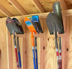 Shovels hanging on wood tool hooks under shed rafters