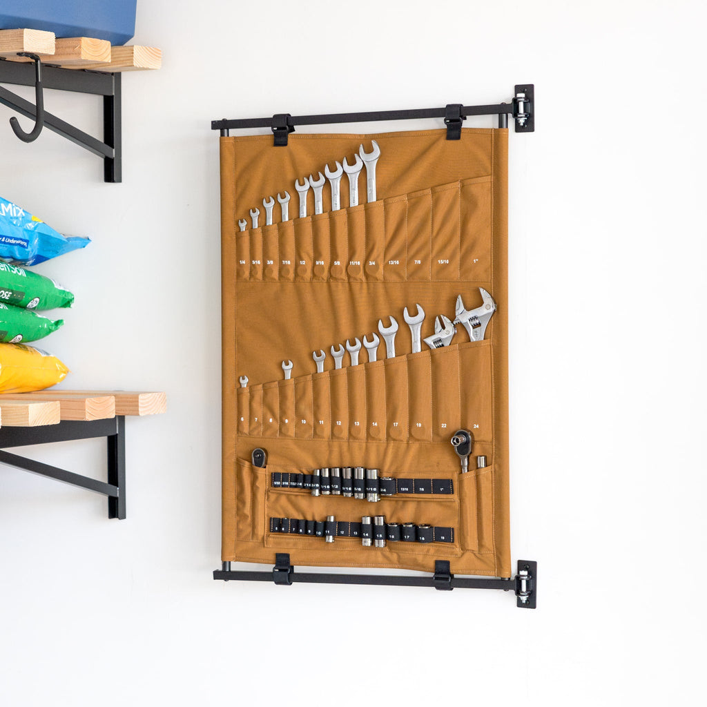 Tan canvas Pivot Panel tool organizer holding wrenches and screwdrivers on a wall