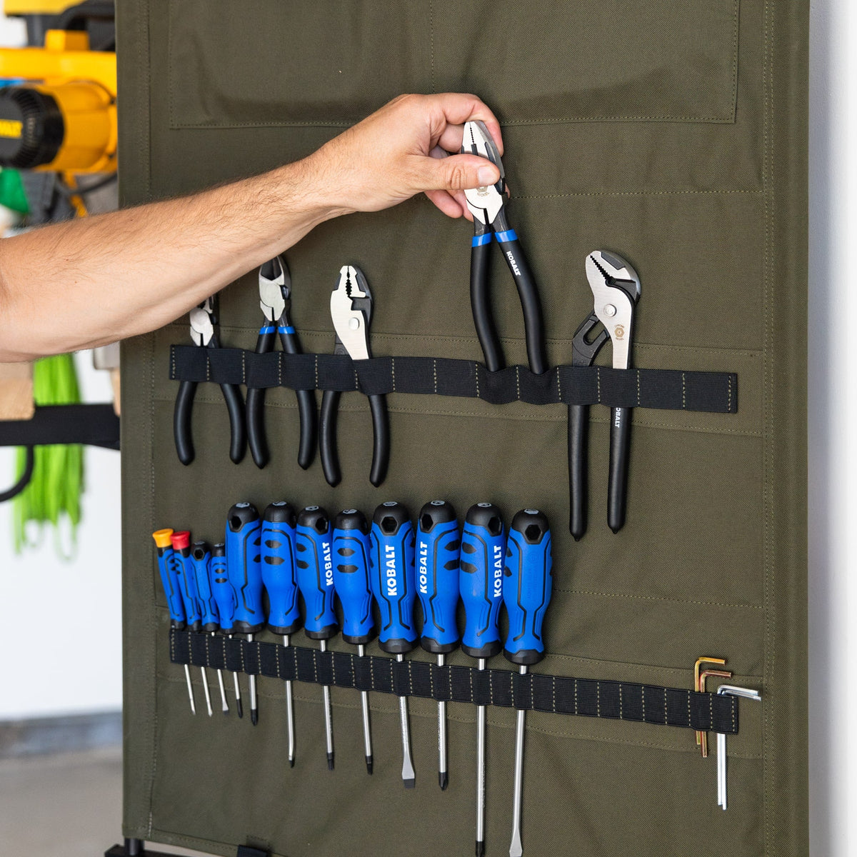 Hand taking pliers from the green Pivot Panel