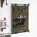 Green canvas Pivot Panel holding pliers and screwdrivers beside a wall shelf