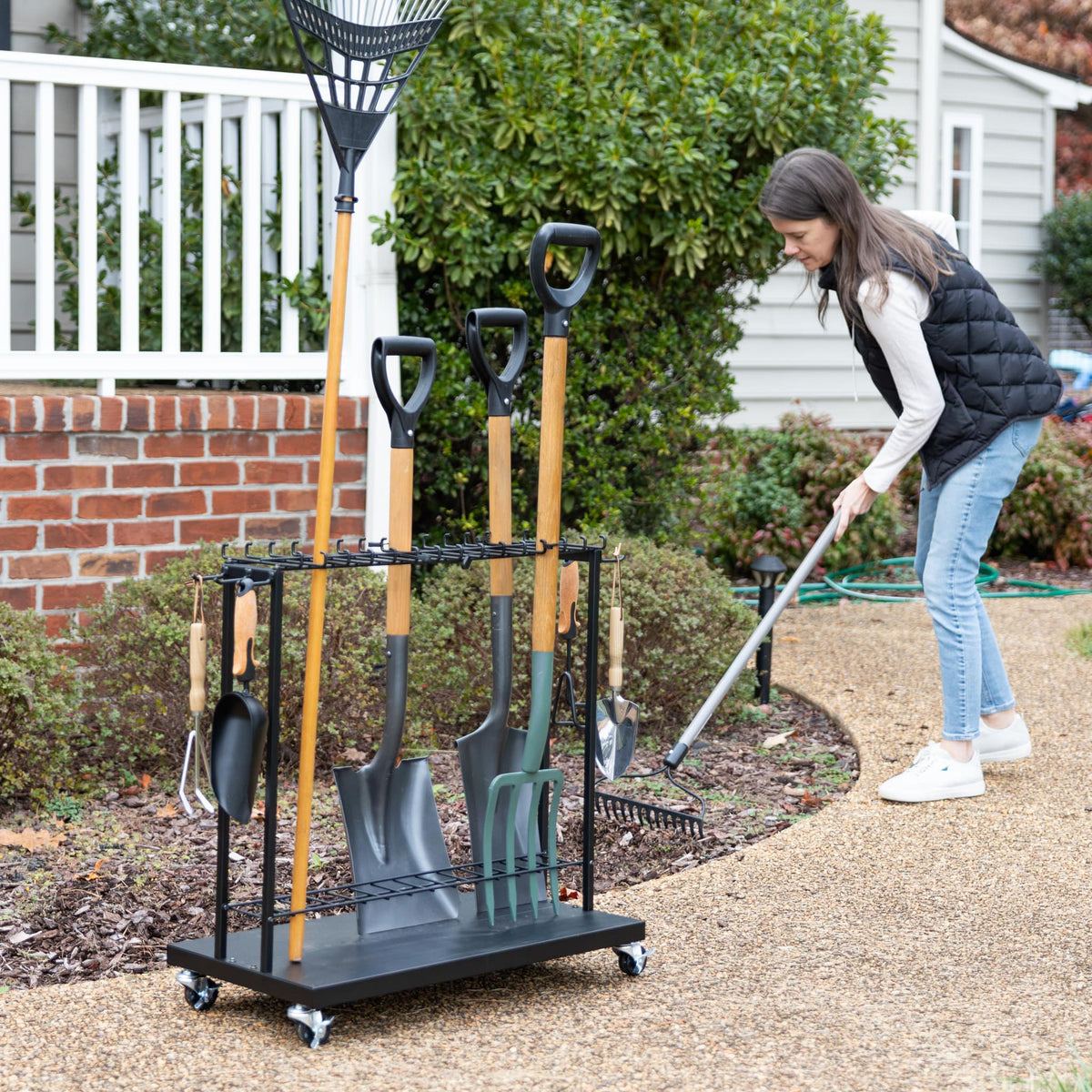 Woman using a rake beside the Shovel Shuttle holding garden tools