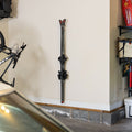 Pair of skis stored vertically on a clear Summit wall rack in a garage