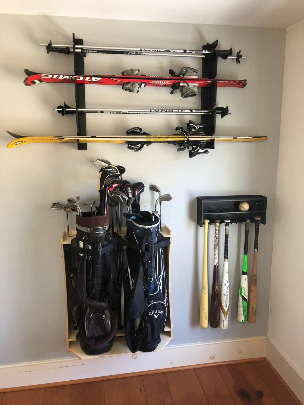 Ski and fishing rod racks mounted above golf bags in a room