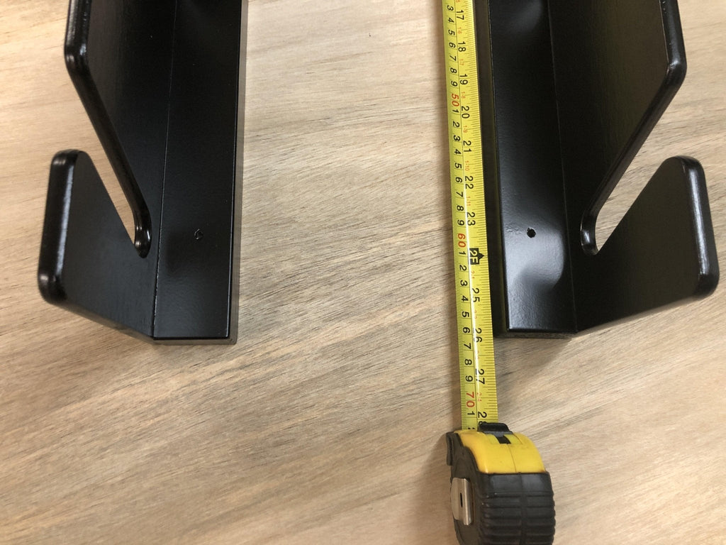Black ski rack rails with a tape measure showing their depth