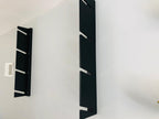 Two black ski rack rails mounted on a wall
