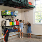 Two children reaching for fishing rods stored on the wall rack in a garage