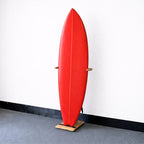Red surfboard in the wood SurfStand, front view