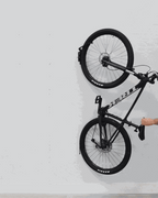 Hand swiveling a hanging bike toward the wall