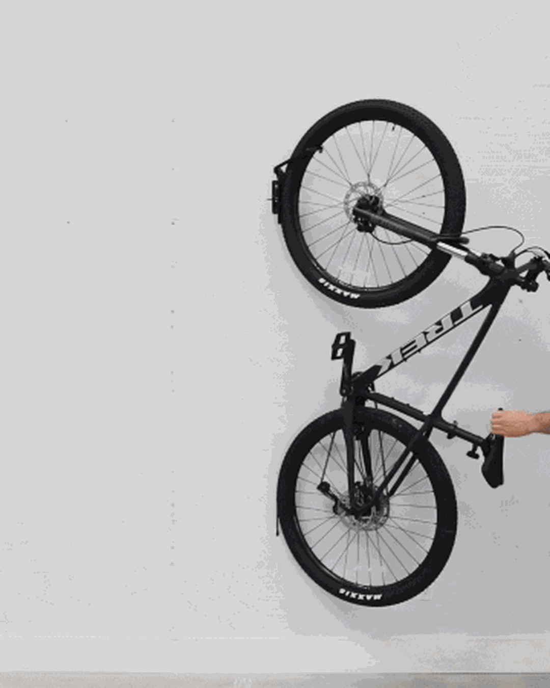 Hand swiveling a hanging bike toward the wall
