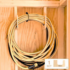 Extension cord coiled on a wood hose hook