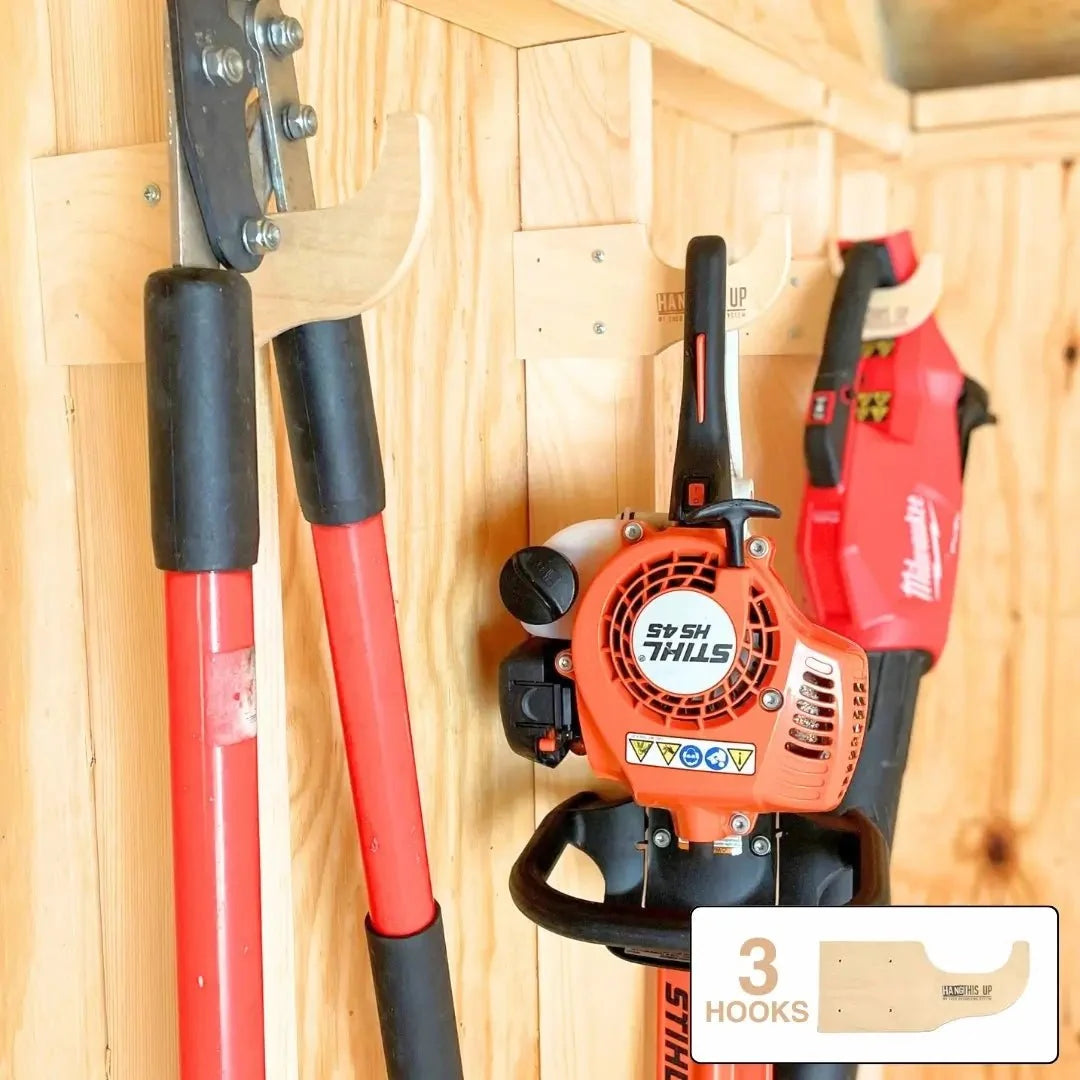 Wood hooks holding loppers and a hedge trimmer