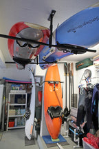Boards and kayaks stored on the ceiling rack, viewed from below