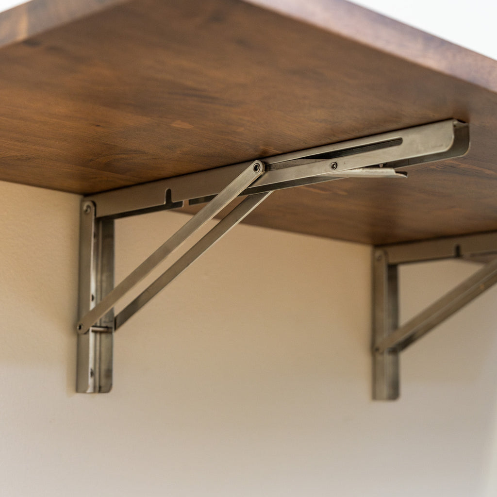 Close-up of the stainless folding brackets under the workbench