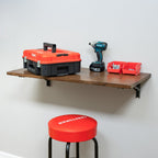 Folding workbench holding a toolbox and drill above a stool