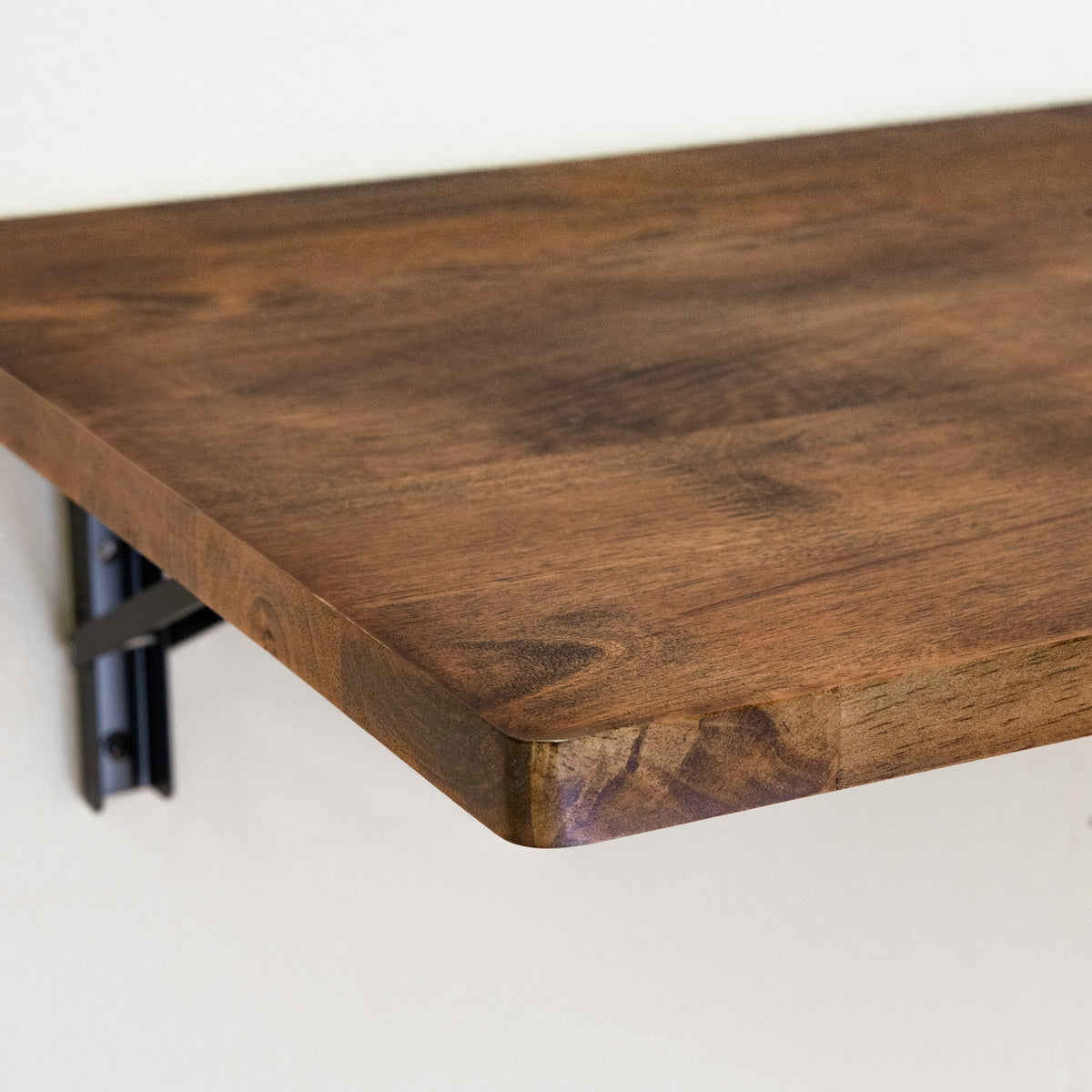 Close-up of the dark wood top and black folding bracket