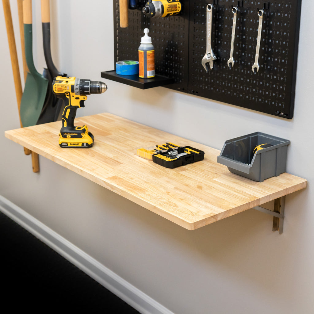 Natural wood folding workbench with a drill and bins below a pegboard