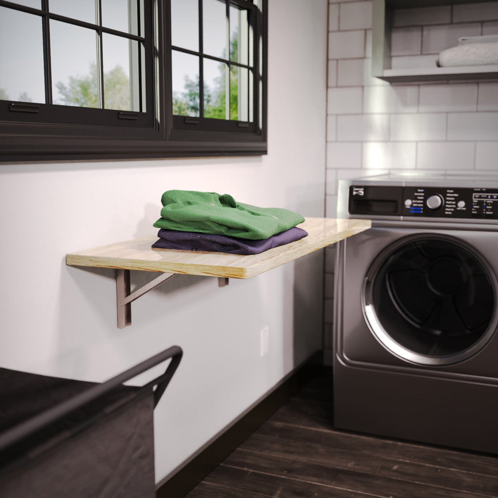 Natural wood folding shelf used for folding laundry beside a washer