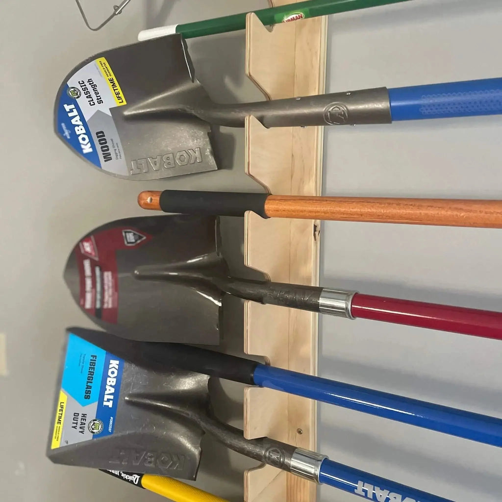 Close-up of shovels resting in the garden tool rack