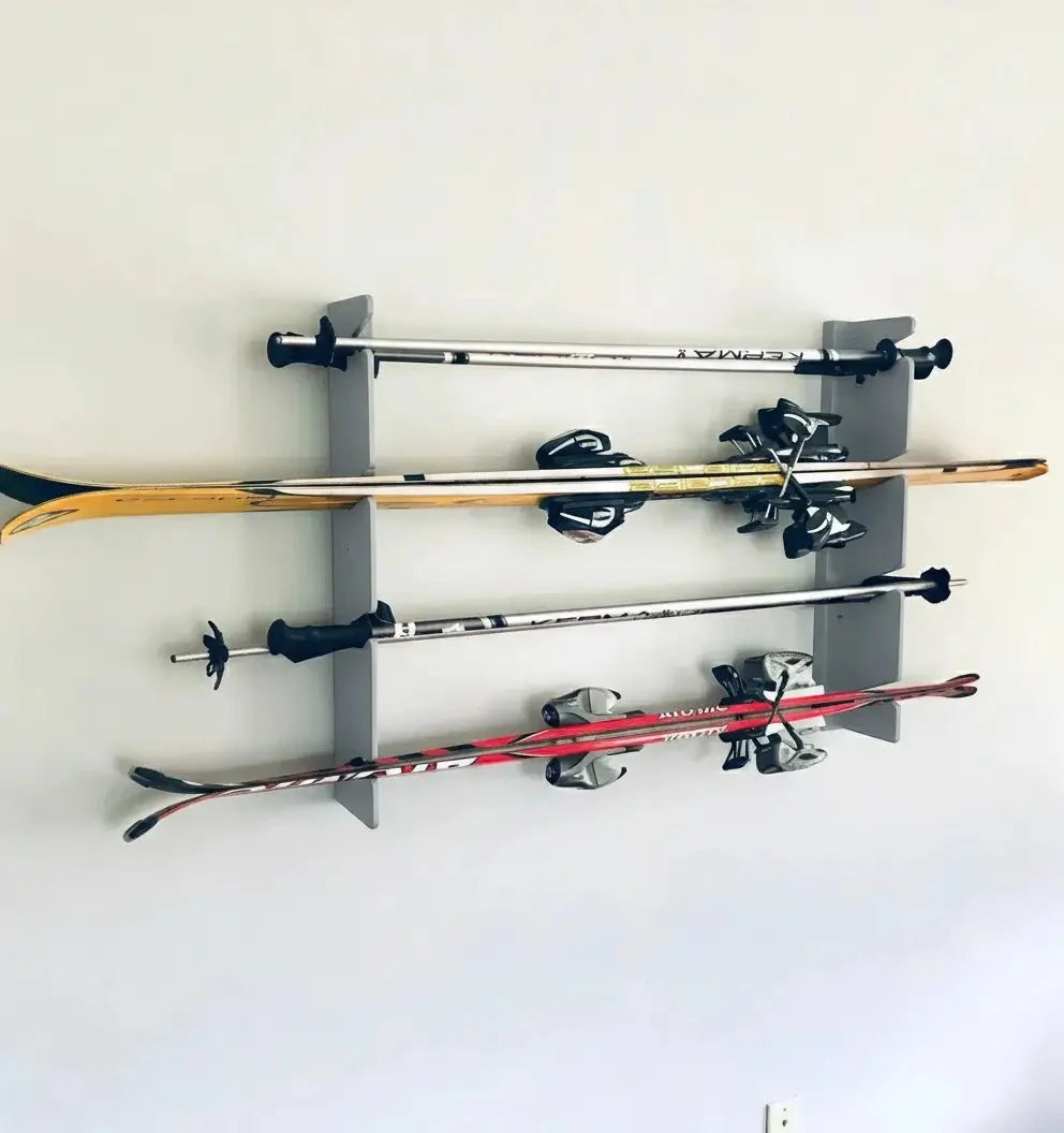 Gray ski rack holding four pairs of skis on a wall