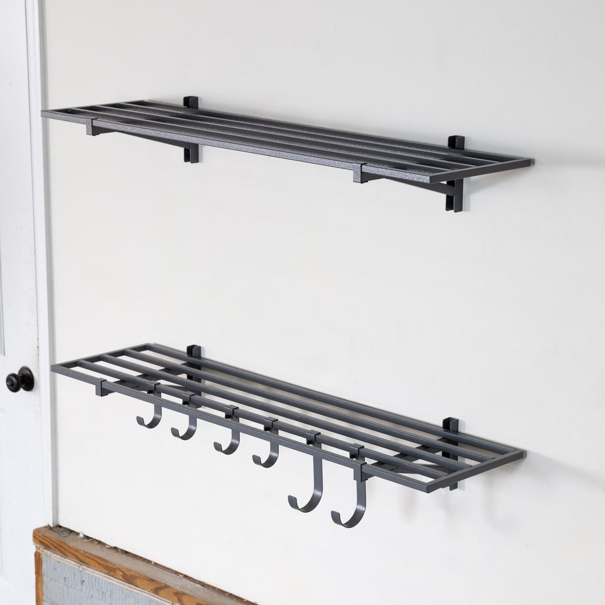 Two empty gray 1 x 4 ft wall shelves, the lower one with hooks