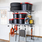 Two gray 2 x 4 ft garage wall shelves holding tires, storage bins, cords and tools