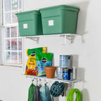 Two white 1 x 4 ft wall shelves holding green totes and garden supplies
