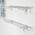 Two empty white 1 x 4 ft wall shelves, the lower one with hooks