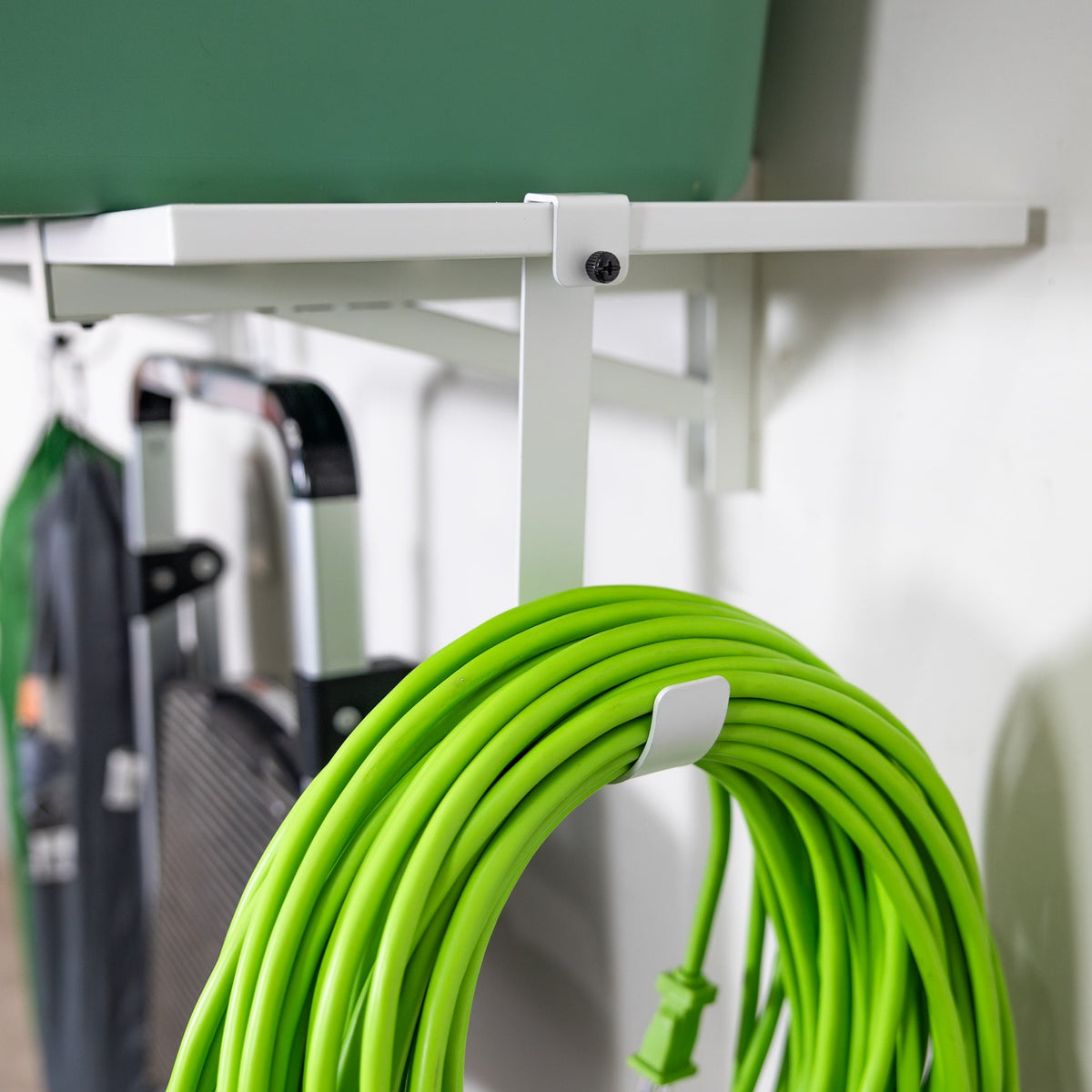 Close-up of an extension cord hanging on a hook under a white shelf