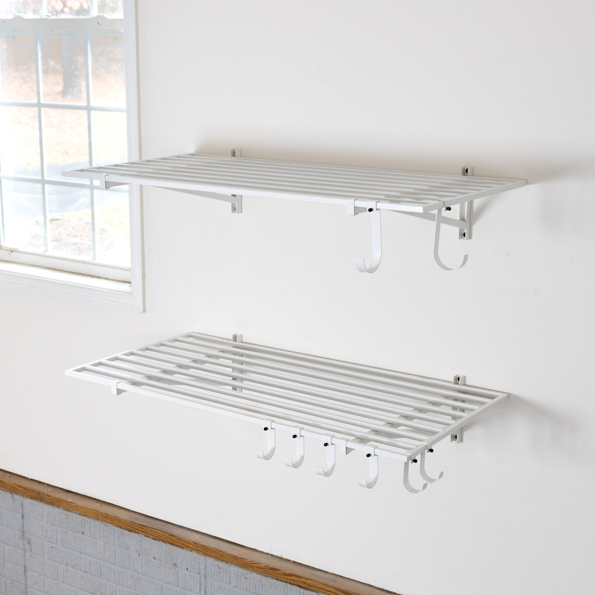 Two empty white 2 x 4 ft wall shelves with hooks underneath