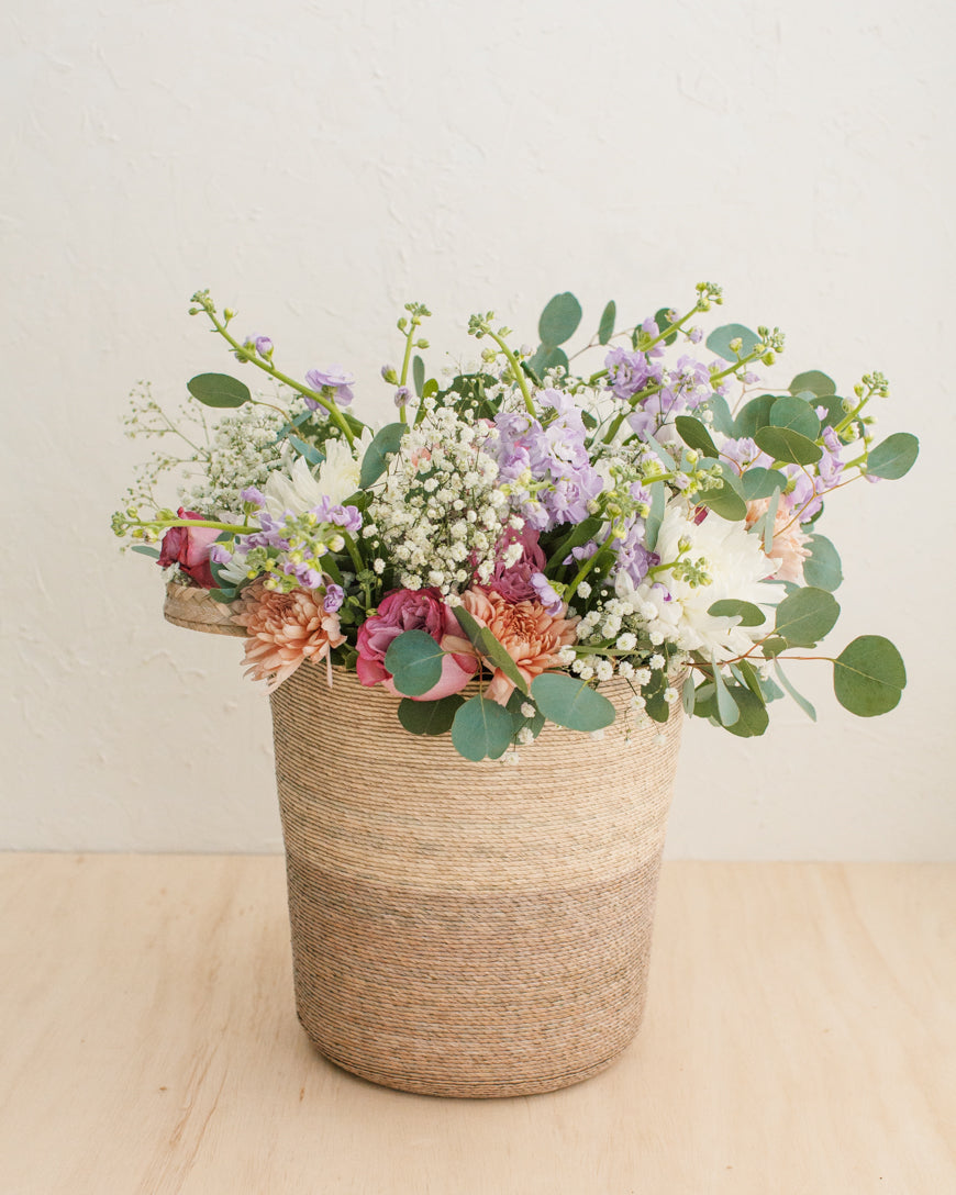 Prado woven palm basket styled with a colorful flower arrangement
