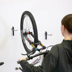 Woman hanging a bike on a WheelRest wall hook