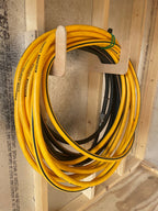 Hose coiled on a wood hose hook on a shed wall